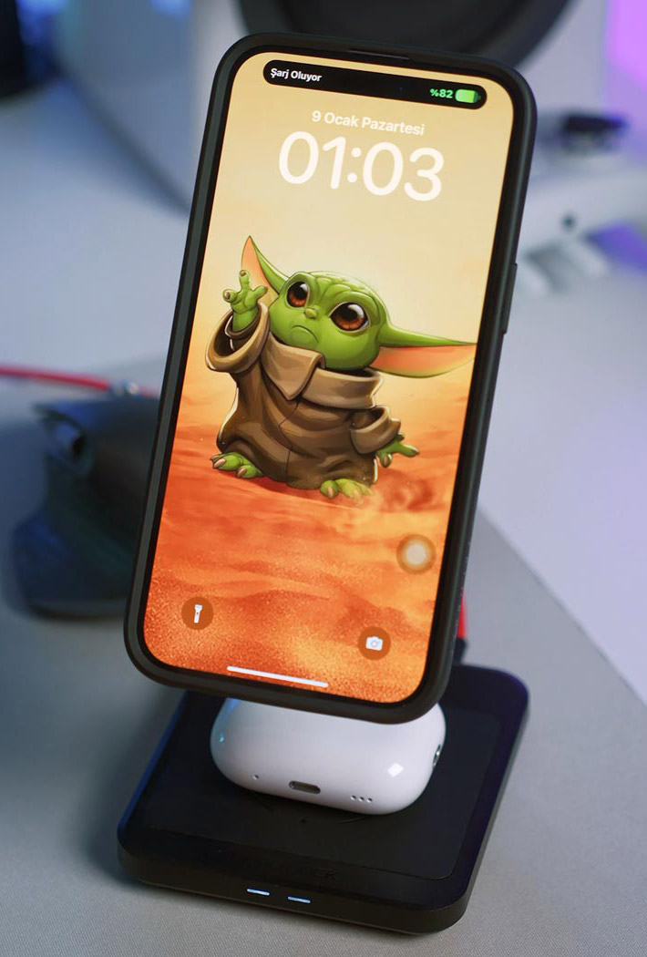 Gesperrtes iPhone in einer Halterung mit einem kleinen Yoda als Hintergrundbild.