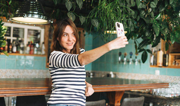 Frau in schön dekoriertem Ambiente macht ein Selfie